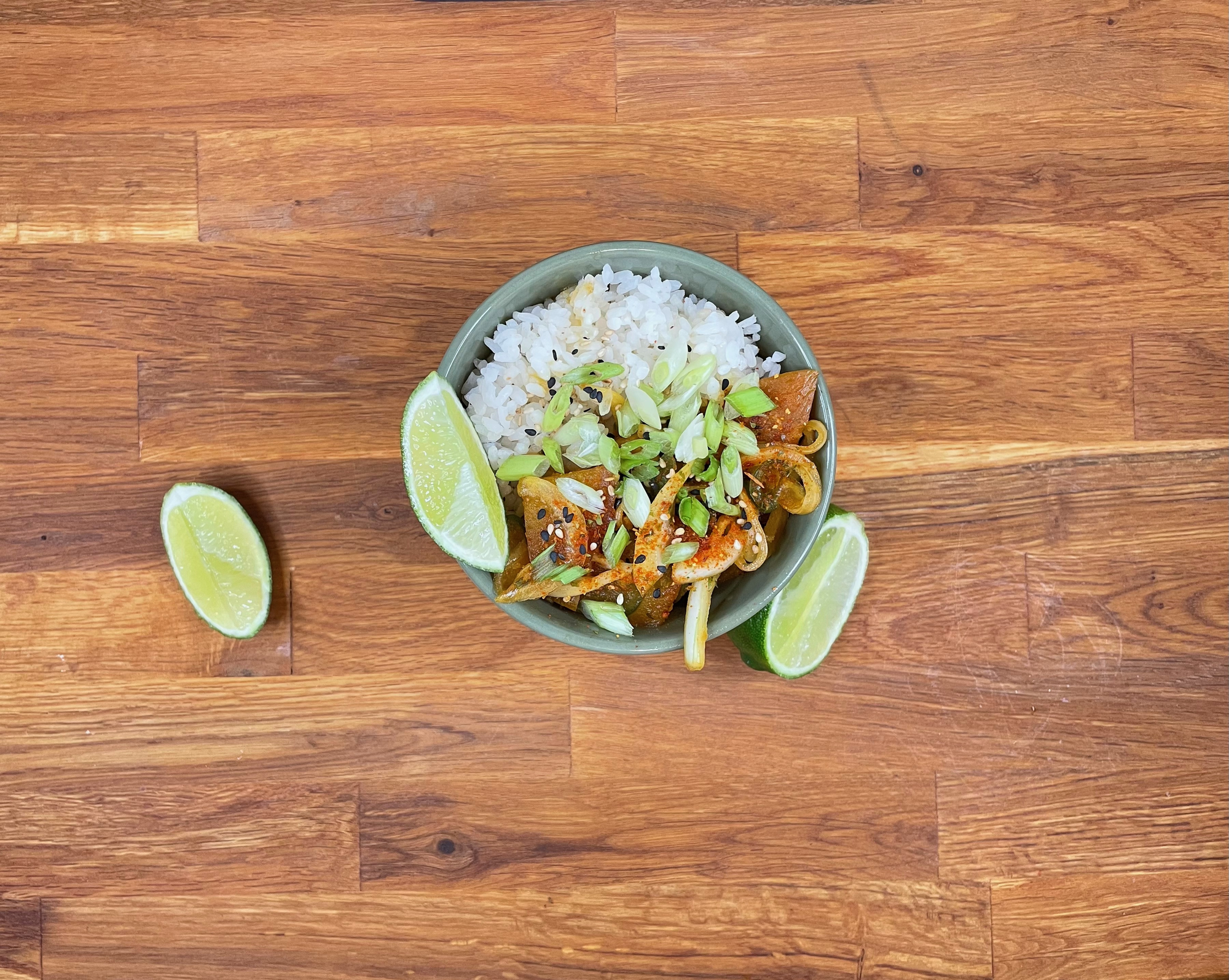 Overhead shot of the bowl of golden beet poke topped with a lime wedge. Another like wedge sits to the left and half of a lime sits to the right. 